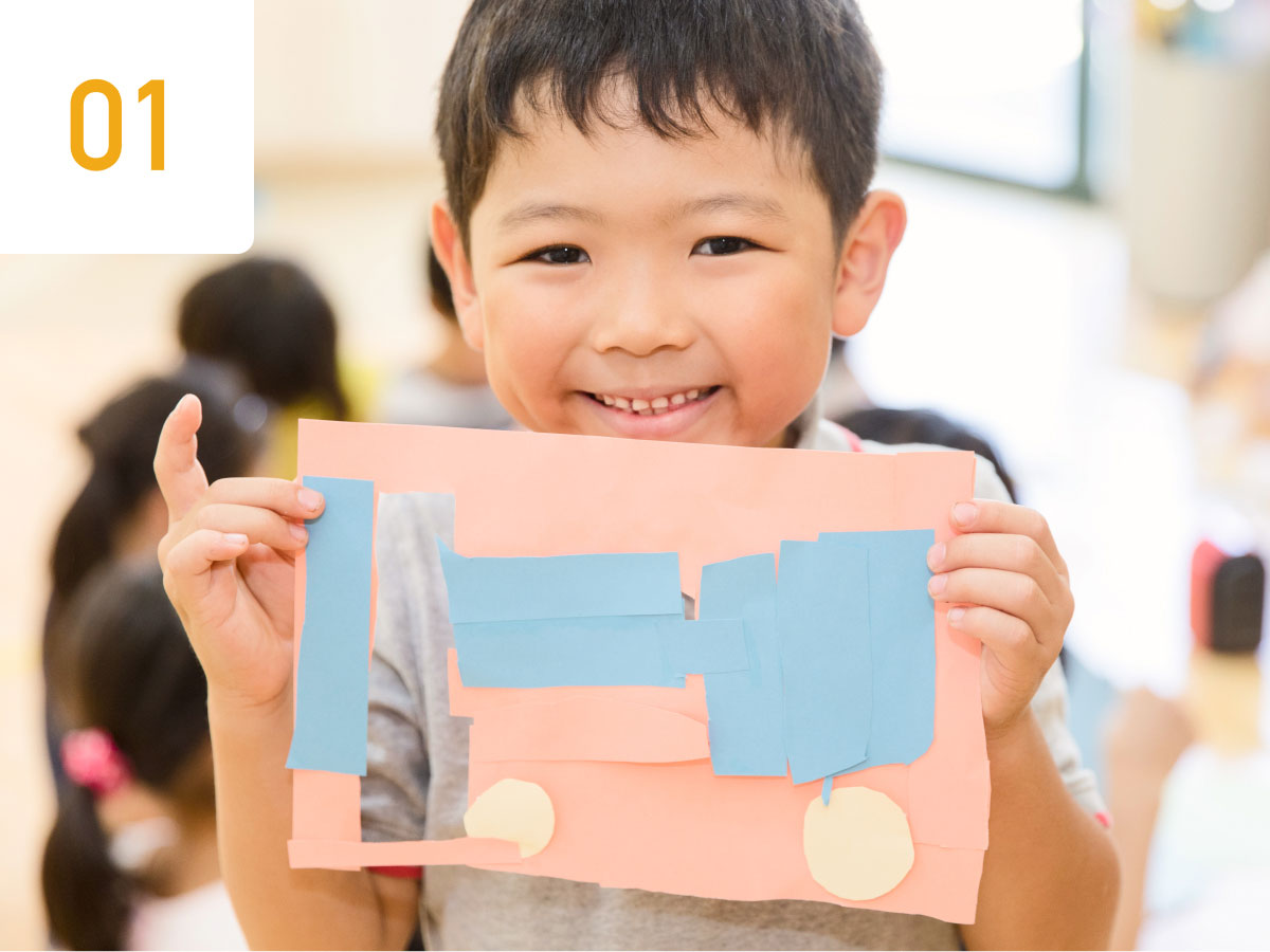 作成した工作物を掲げる子ども